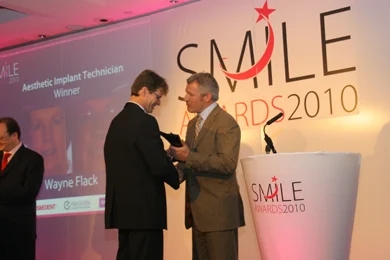 Wayne Flack receiving the Aesthetic Implant Technician award on stage at the Smile Awards 2010